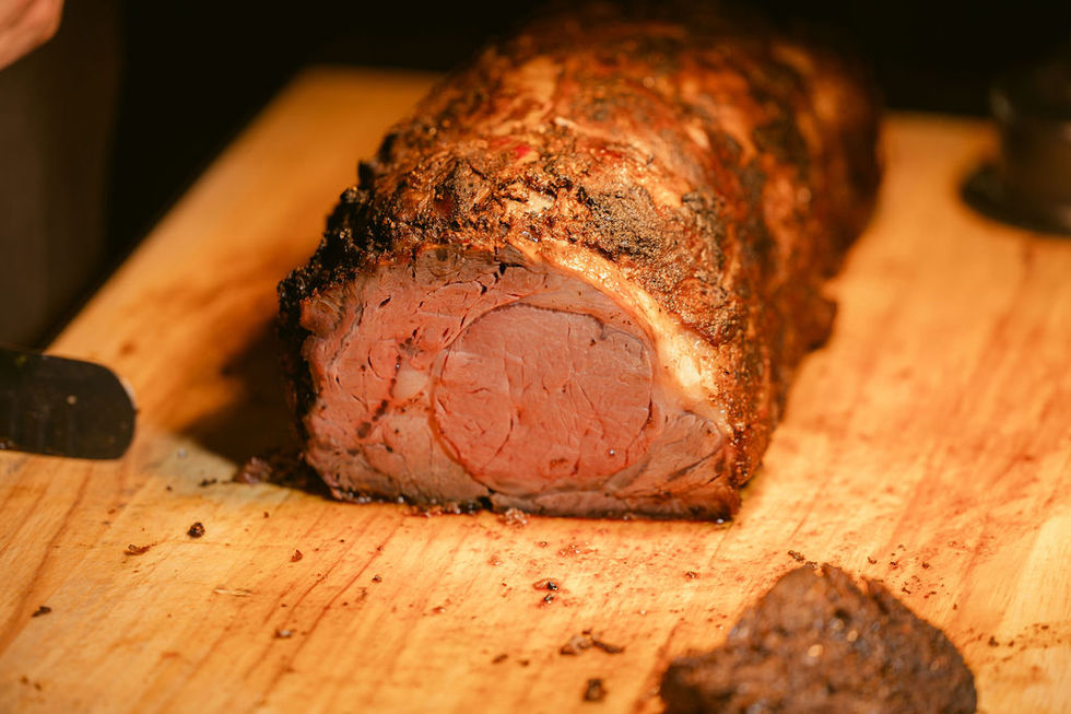a large piece of meat is sitting on a wooden cutting board