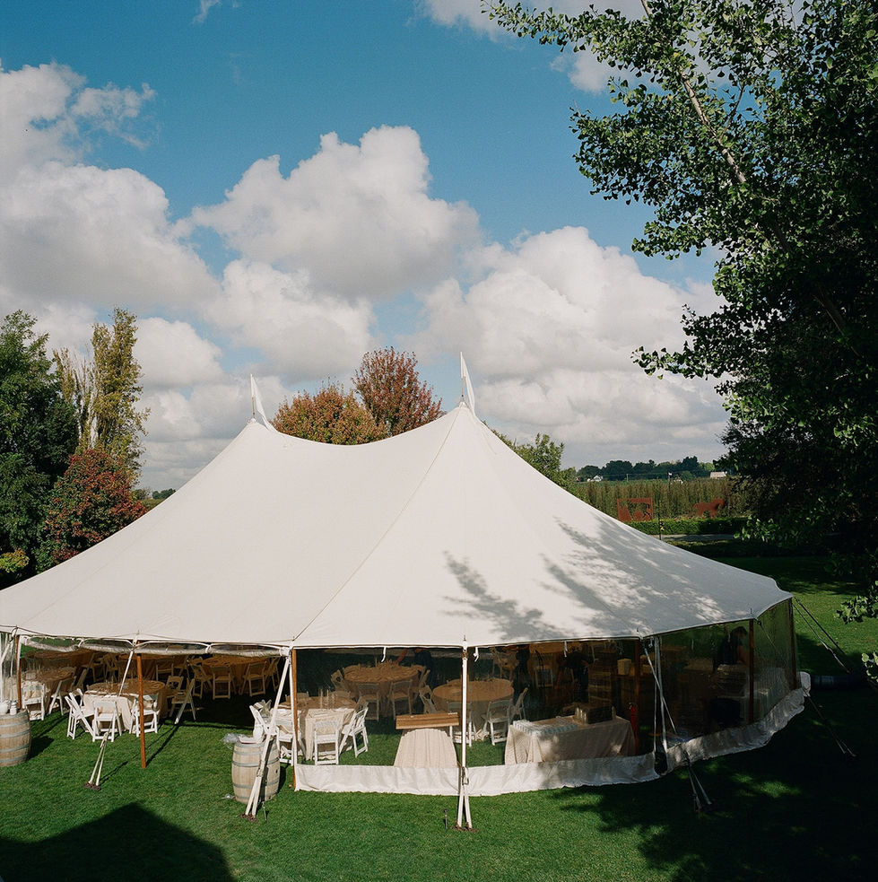 a large white tent with tables and chairs inside of it
