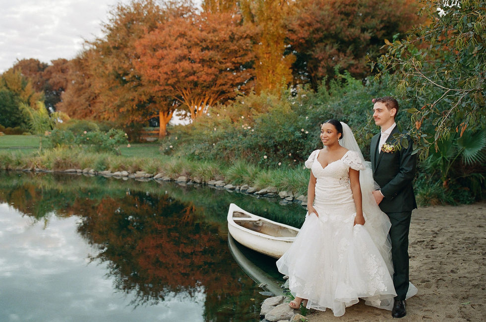a bride and groom standing next to a white boat