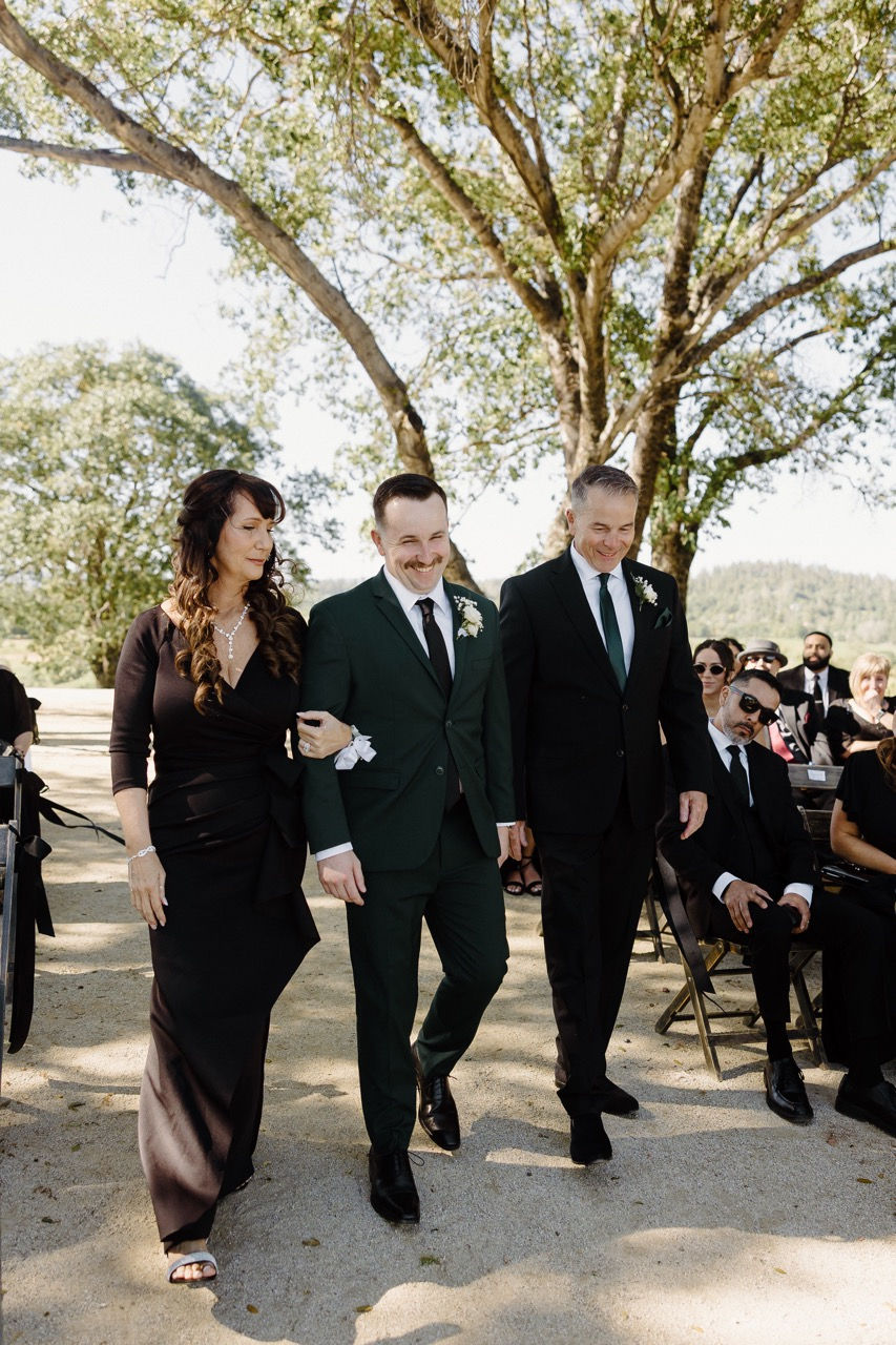 a man in a green suit is walking down the aisle