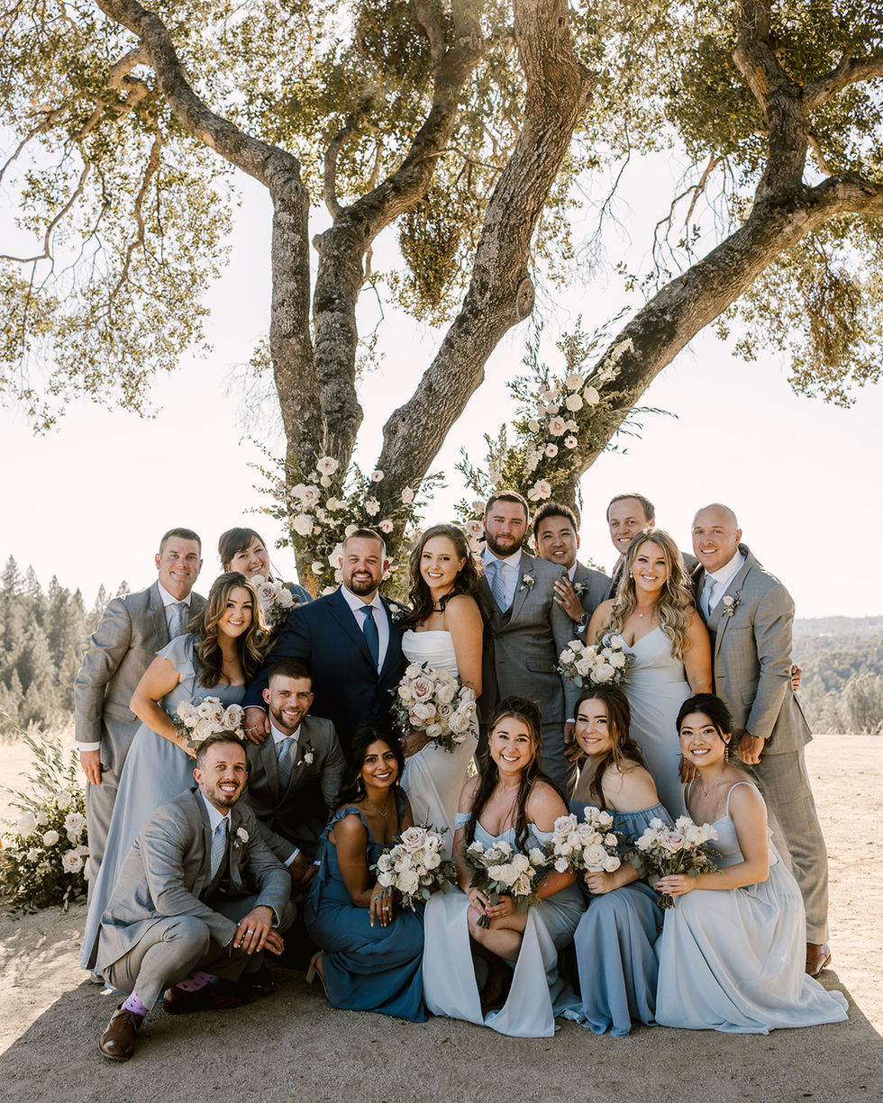 a group of people posing for a picture under a tree
