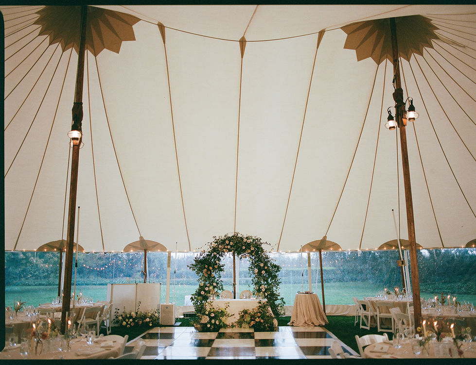 the inside of a tent with tables and chairs and a dance floor