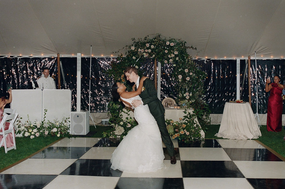 a bride and groom are dancing on a checkered dance floor