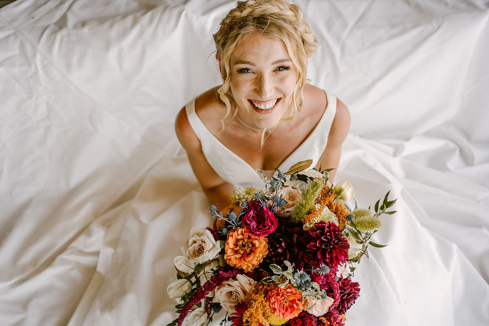 the bride is smiling while holding a bouquet of flowers