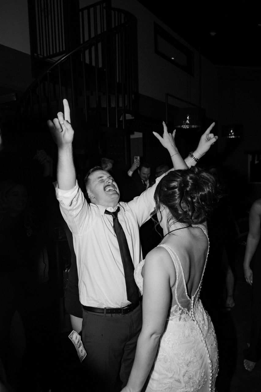 a man and a woman are dancing with their arms in the air