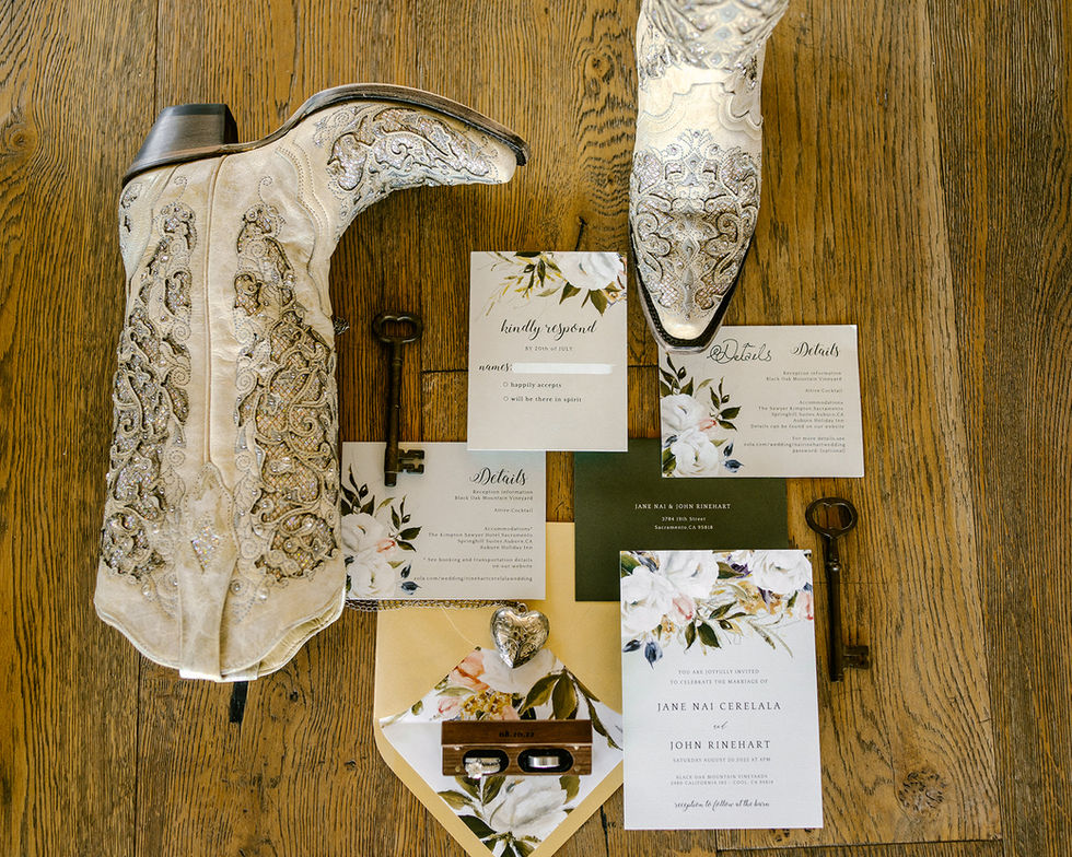 a pair of cowboy boots sit next to a wedding invitation