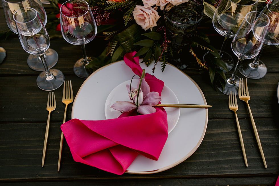 a plate with a pink napkin and a flower on it