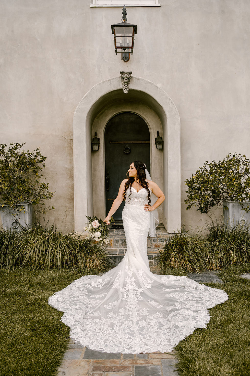 a woman in a wedding dress is standing in front of a building