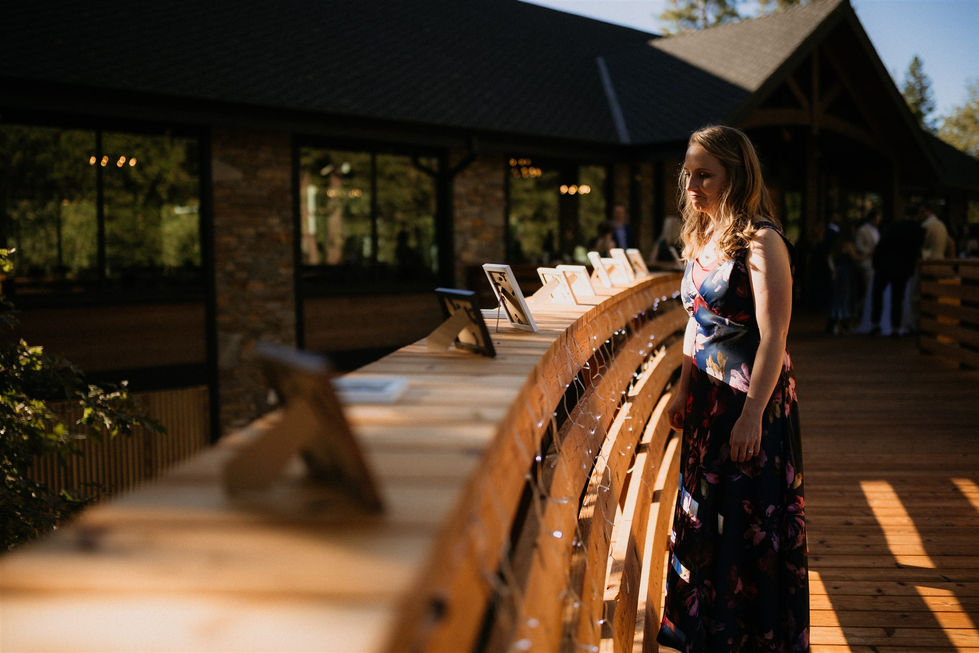 a woman in a blue dress stands in front of a wooden table with pictures on it