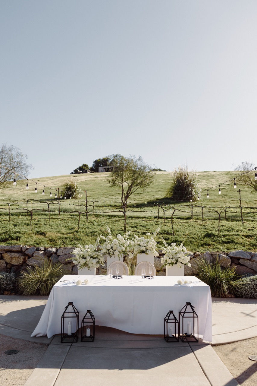 a bride and groom 's table with white flowers on it