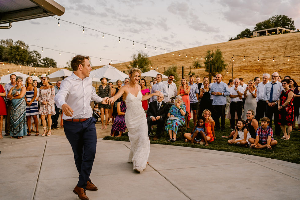 a bride and groom are dancing in front of a crowd of people