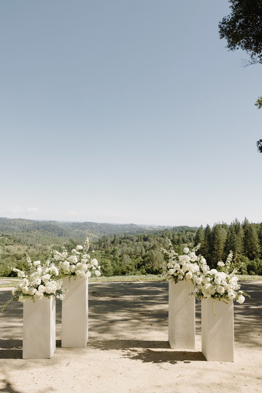 a row of white pillars with white flowers on them