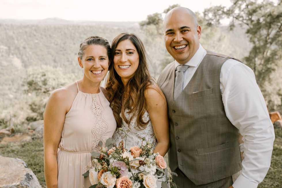 a bride and groom pose for a picture with their bridesmaid