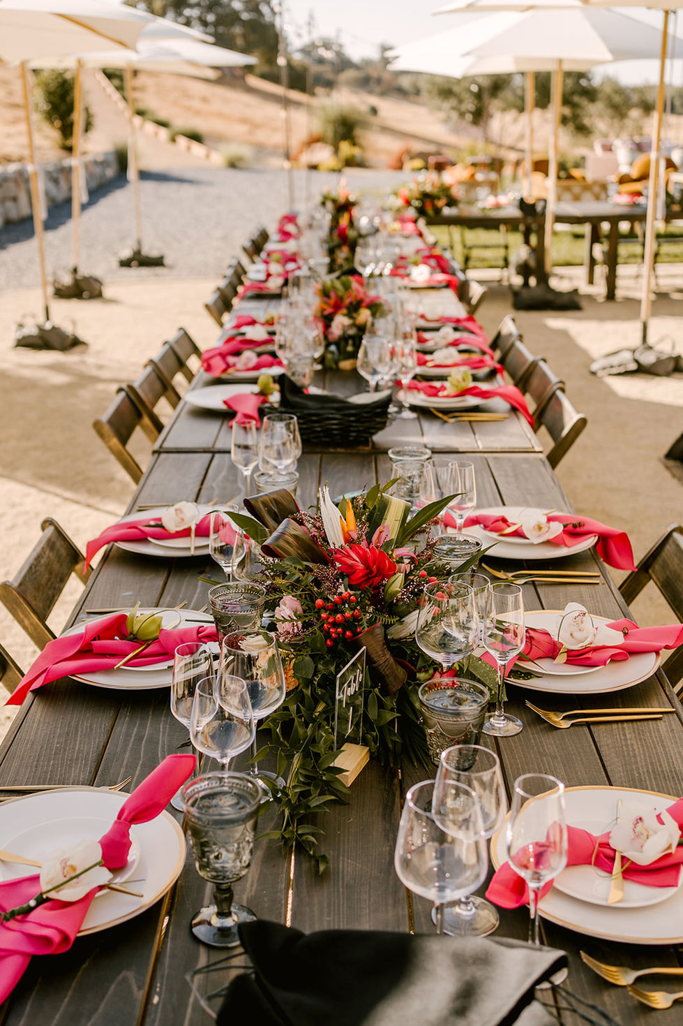 a long wooden table with plates and glasses and a table number