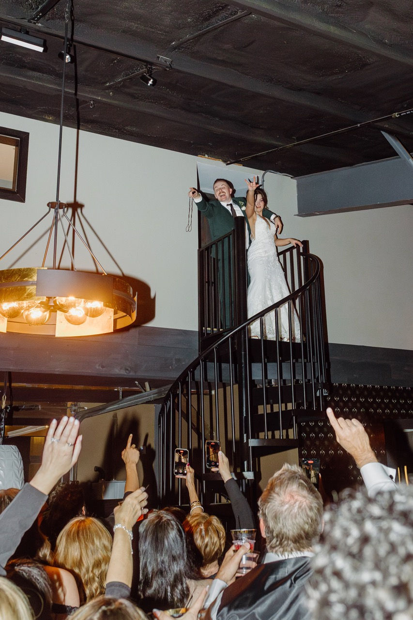 a bride and groom are standing on a spiral staircase