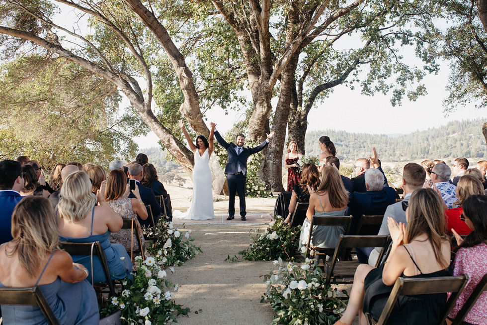 a bride and groom are celebrating their wedding under a tree