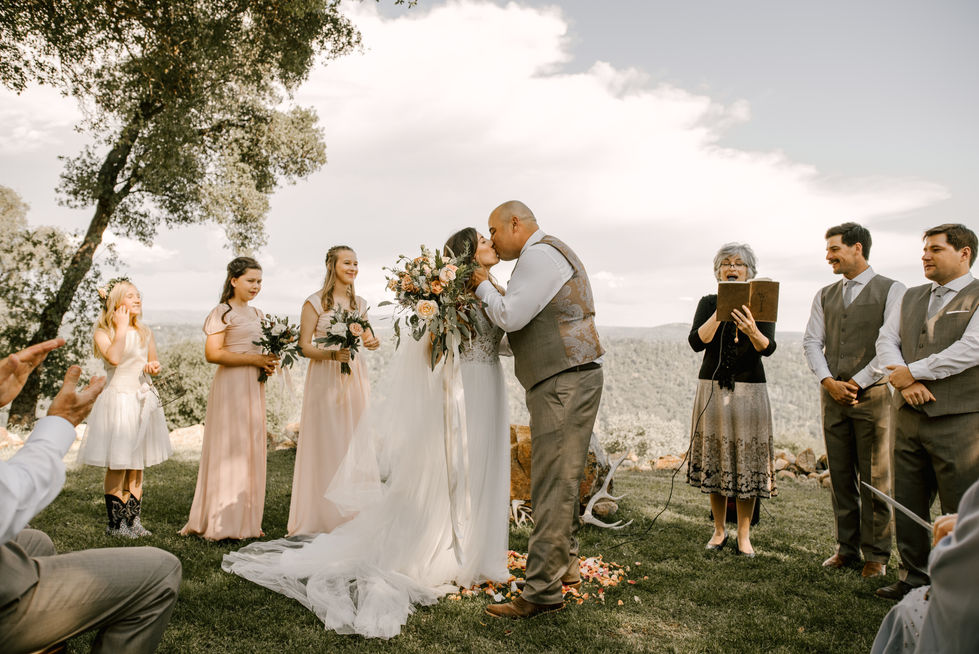 a bride and groom kiss during their wedding ceremony