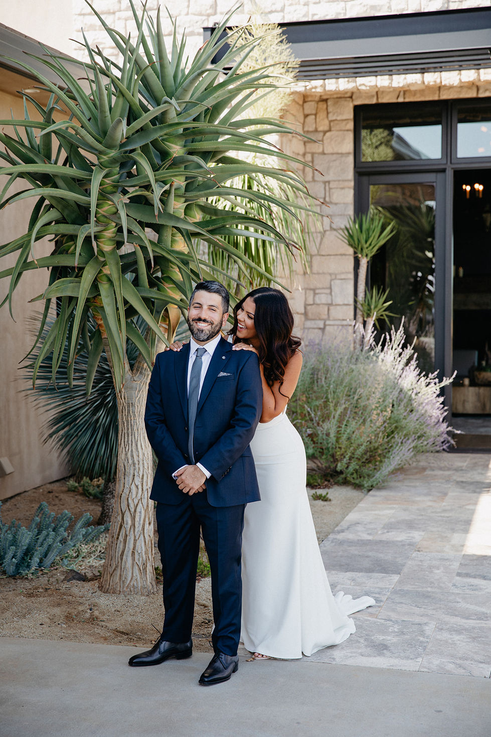 a man in a suit and tie stands next to a woman in a white dress
