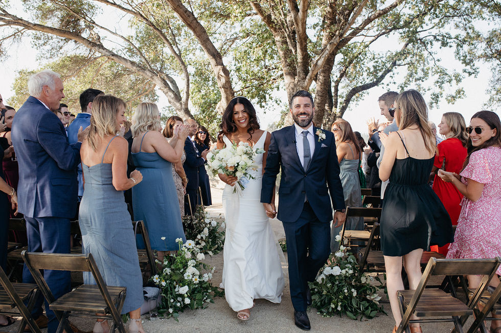 a bride and groom are walking down the aisle at their wedding