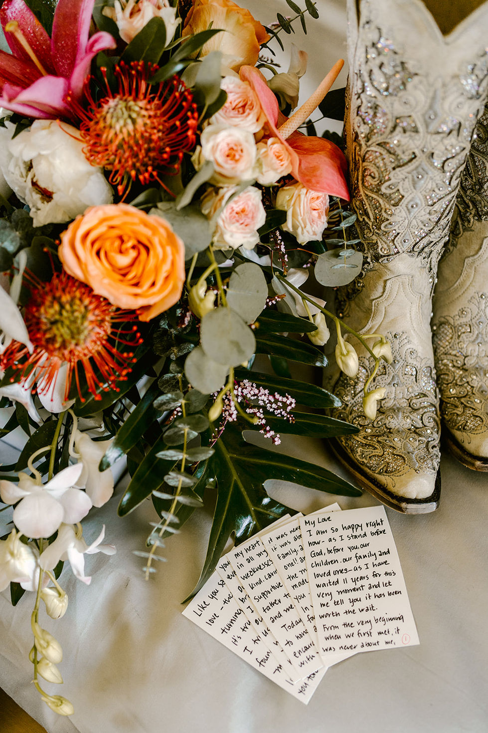 a bouquet of flowers sits next to a pair of cowboy boots