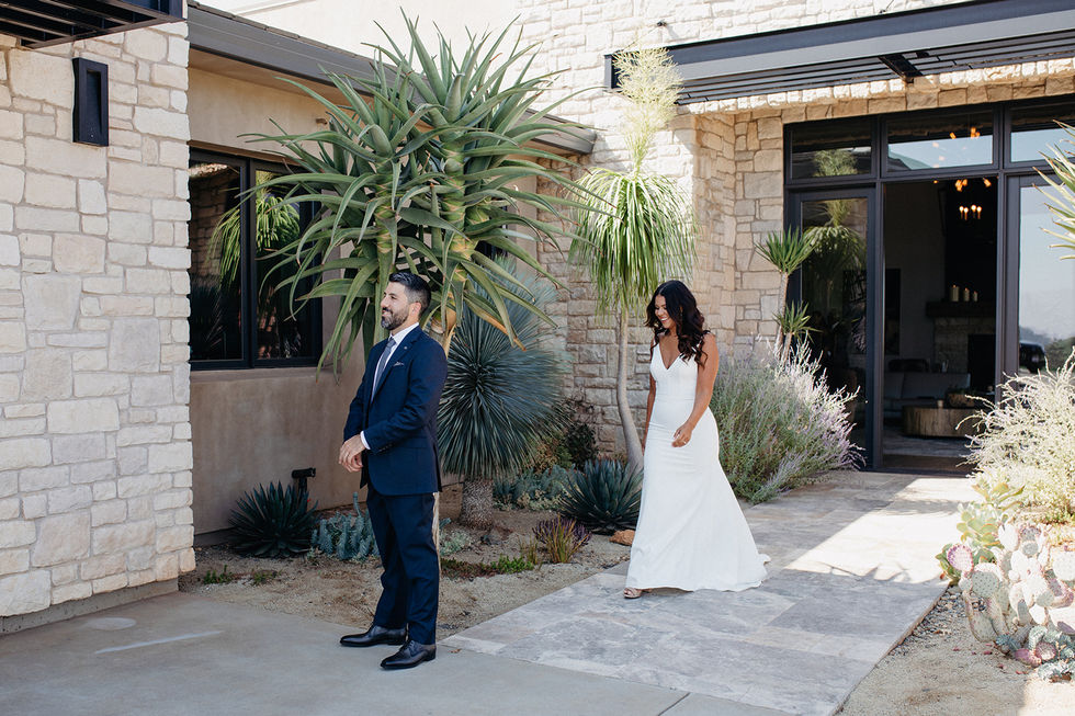 a bride and groom are standing in front of a stone building