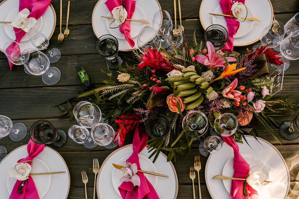 a table setting with plates glasses and flowers on it