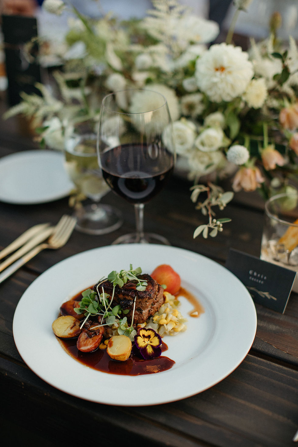 a plate of food with a glass of wine on a table
