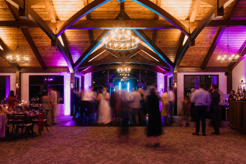 a crowd of people are dancing in a room with a chandelier