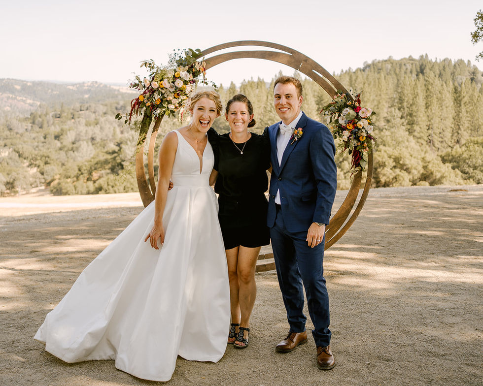 a bride and groom pose with their wedding planner