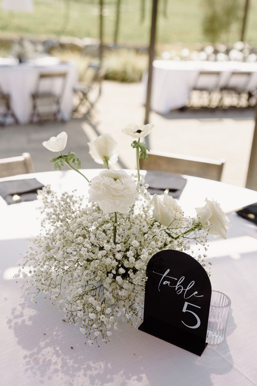 a table with white flowers and a table number 5