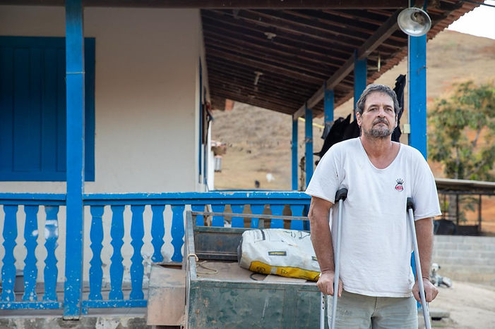 imagem de um senhor a frente de uma cerca azul