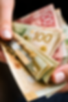 Close-up of hands holding Canadian dollar notes representing flight delay compensation payout up to CAD 1000