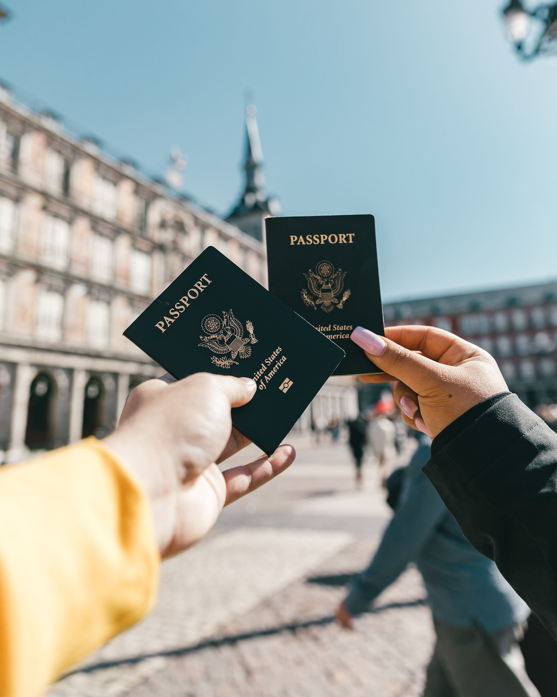 Two hands holding up passports