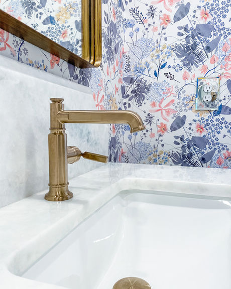Gold faucet, floral wallpaper, marble sink