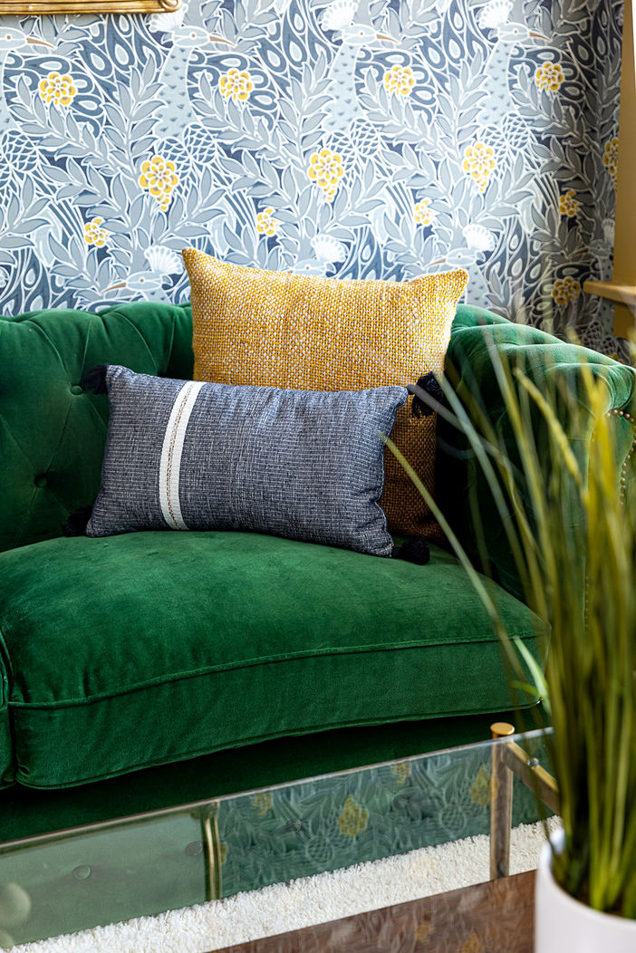 Green velvet sofa with mustard and navy pillows