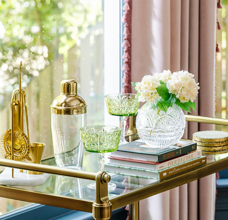 Brass bar cart with drinks and glassware