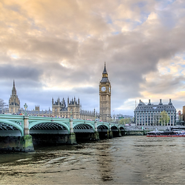 Picture of Westminister Abbey in London with central tower of Big Ben overlooking bridge and water.