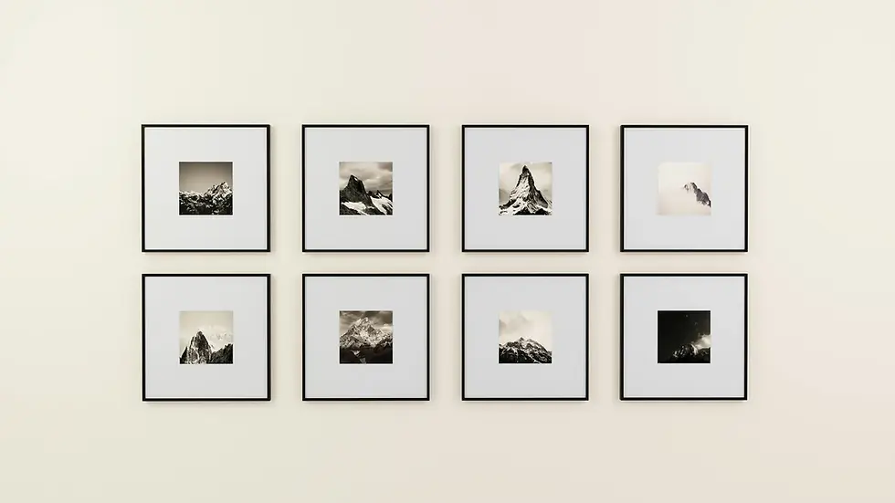 Eight matching black frames with monochromatic mountain prints on warm beige wall showing single-palette gallery wall for modern kitchen