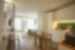 Studio apartment zoned without walls kitchen, dining, and sleeping areas separated by vertical slat partition