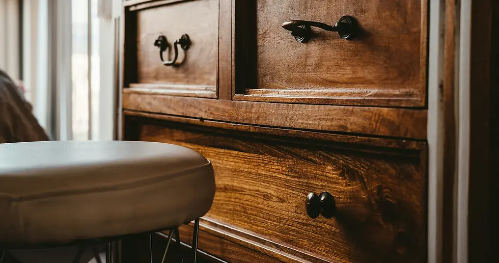Close-up of walnut drawer fronts with dark bronze pull handles, showing the wood grain and matte finish