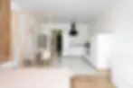 Light wood slat room screen dividing sleeping zone from kitchen in bright Scandinavian studio apartment warm minimalist partition idea