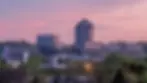 Woodbury, MN office park skyline with the 8500 Tower at pink dusk surrounded by spring green trees
