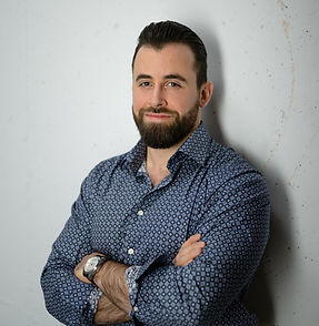 Ein großer, dunkelhaariger Mann mit gepflegtem Vollbart und Hemd - Fabian Baumgarnter des Baumgarnter Baumanagement in Zug