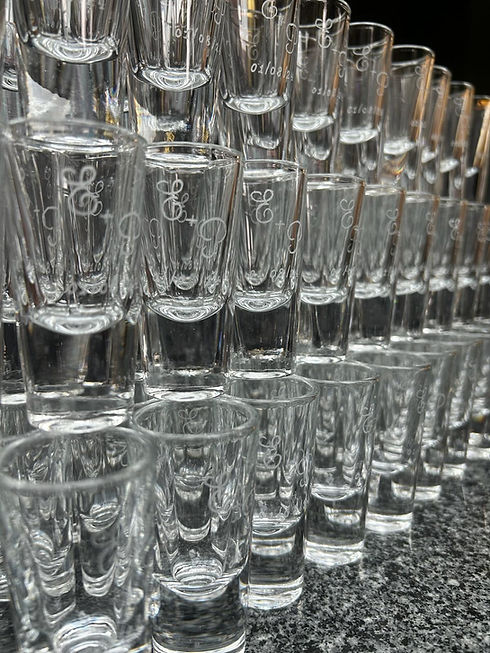 100s of identically engraved stacked shot glasses.