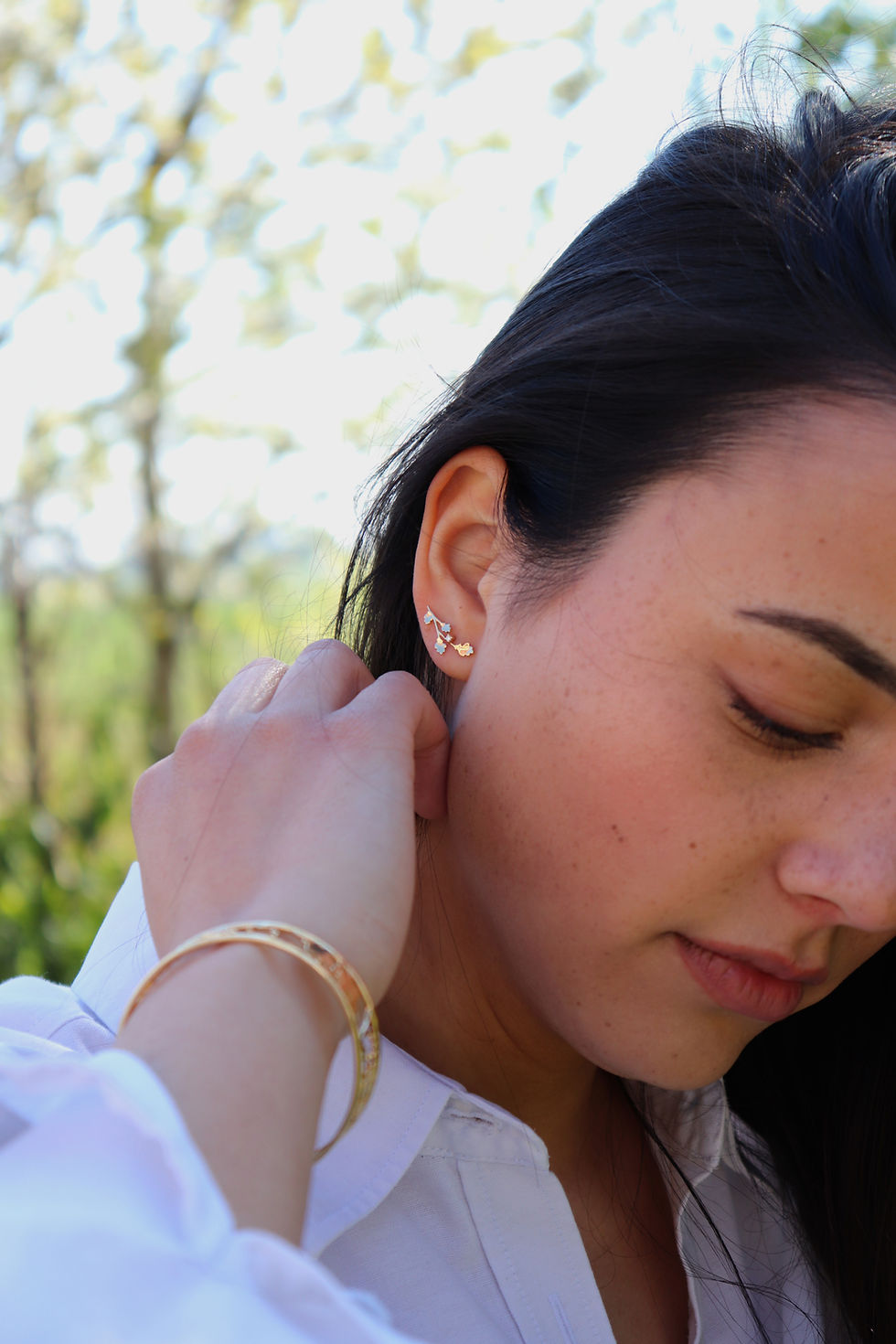 Side view of model wearing 18k gold oak earclimber earrings with white diamonds by Princess Margarita, fine design jewellery.