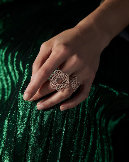 A hand wearing two rings, the nuance ring and the beech ring both in 18k rose gold.