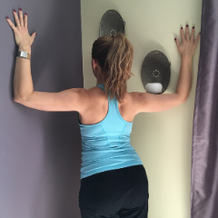 standing at corner and leaning in to stretch the top of the chest.