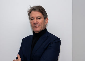 Fabrizio Bosi in giacca e dolcevita nero con le braccia conserte