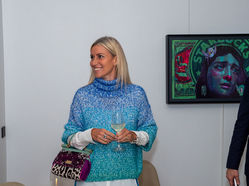 Federica Pesce sorridente con maglione blu e bicchiere