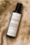 JD Beauty Chamomile Neroli Dry Body Oil bottle among chamomile flowers